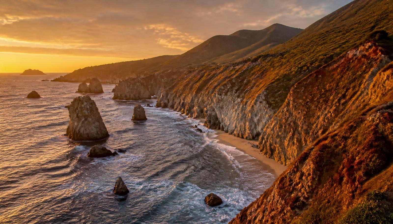 Pacific coastline cliffs and sea stacks at golden hour